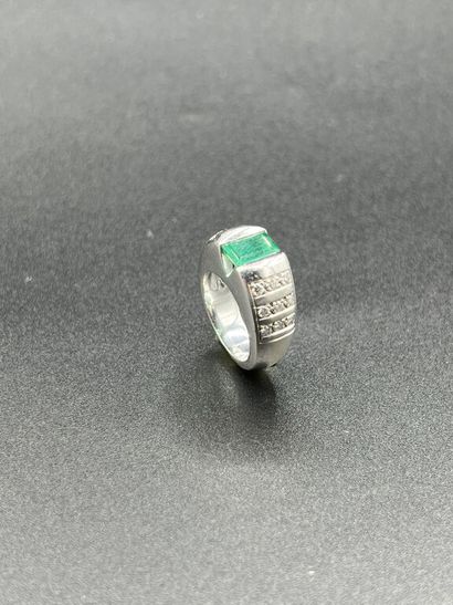null White gold 750 mm flat band ring set with an emerald cut emerald in a half-closed...