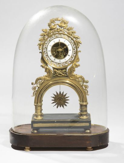 null Skeleton clock in chased and gilded bronze, topped by a pair of birds pecking...