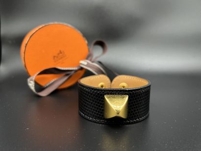 null HERMÈS Paris Made in France

Bracelet « Médor » en lézard noir et métal doré,...