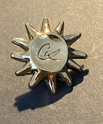  Arthus Bertrand pour CHRISTIAN LACROIX 
Pin's en métal doré figurant un soleil gravé...