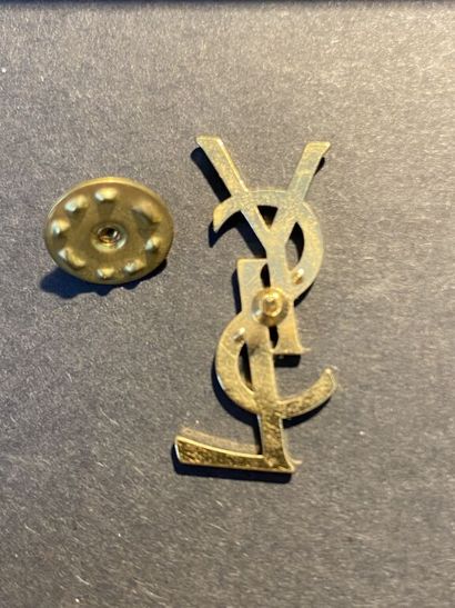  YVES SAINT LAURENT 
Pin's en métal doré représentant le sigle de la Maison. 
Dim....