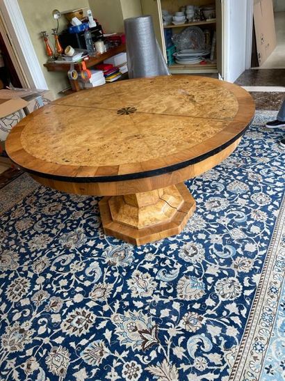 A circular dining room table with extensions,...