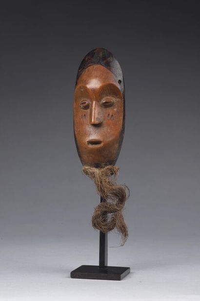 null Kidumu mask with its raffia beard. The concave face is double scarified on each...