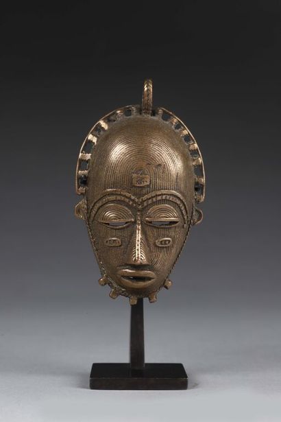 null Pendant representing a mask entirely covered with fine parallel lines and haloed...
