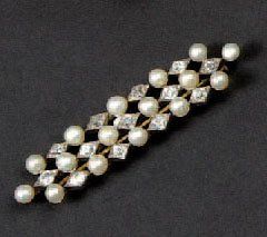 null BROCHE.Ornée de trois lignes de perles de culture et diamants de taille ancienne...