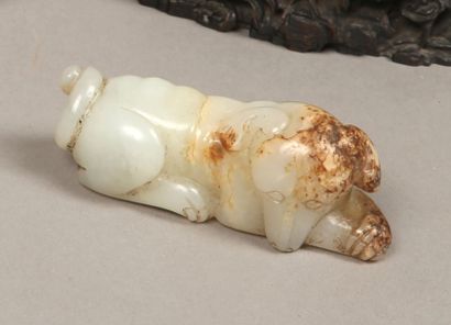 CHINE Petit chien couché en jade, sa tête appuyée sur ses pates. L: 8,2 cm A jade...