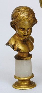 null Cachet en bronze doré représentant le portrait en buste d'un enfant reposant...