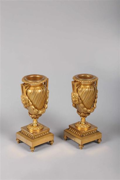 null Paire de petits vases en bronze doré à côtes torses, les anses soutenant une...
