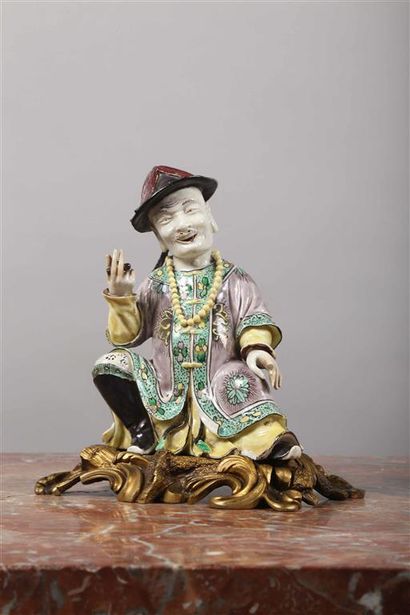 null CHINE.
Statuette en porcelaine représentant un personnage assis au chapeau
à...