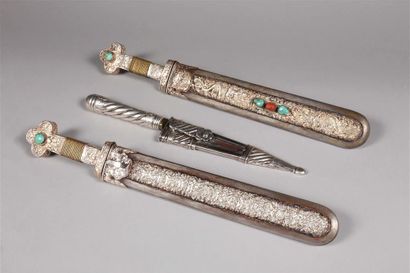 null Paire de dagues chinoises à décor en métal argenté en repoussé
de dragons, têtes...