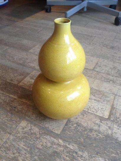 null Un vase double gourde en porcelaine à fond jaune à décor de feuillage et entrelacs.
Marque...