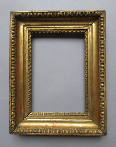 null A carved and gilded wooden frame decorated with rais de coeur and friezes of...