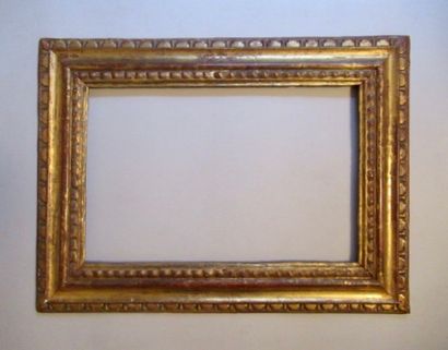 null Carved and gilded wooden frame with inverted profile and stylized friezes of...