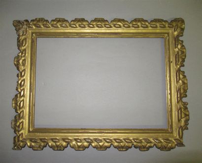 null A carved and gilded wooden frame with stylized ribbon and acanthus leaf friezes.

Italy,...