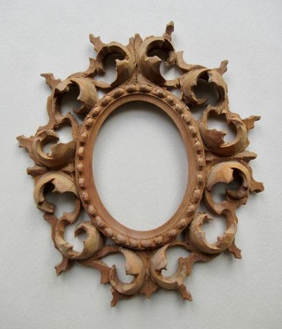 null Cadre en bois naturel sculpté de forme oval et décor de rais de perles et enroulements...