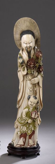 null Statuette en ivoire polychrome sculpté figurant un personnage debout, un bouquet...