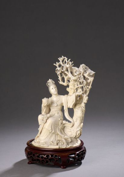 null Sujet en ivoire sculpté figurant une jeune femme assise près d'un prunus, un...