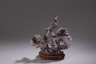 null Amethyst quartz subject representing a bird of paradise perched on a flowering...