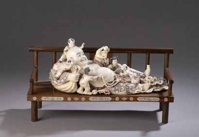 null Carved ivory subject enhanced with ink, Budai reclining on the bag of riches,...
