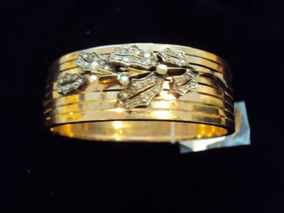 null BRACELET rigide ouvrant en or jaune appliqué d'un motif de fleur en argent,...