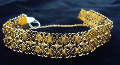 null BRACELET articulé en or jaune ajouré partiellement orné de demi-perles. Poids...