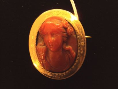 null BROCHE ovale en or jaune ornée d'un camée corail représentant une femme en buste....