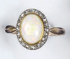 null BAGUE en or (18k, 750 millième) deux tons ornée en son centre d'une opale taillée...