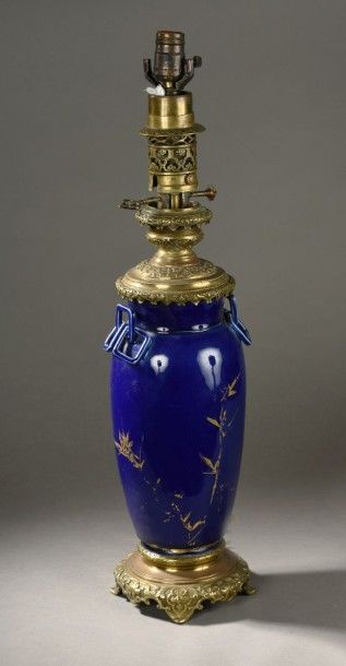 null LAMPE A PETROLE en porcelaine composée d'un vase à fond bleu et décor doré de...
