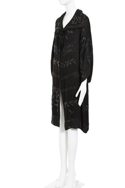 N/A Un manteau du soir en crêpe noir perlé, années 1920,

A beaded black crêpe evening...