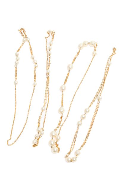 CHANEL Four large imitation pearl necklaces and chains, 1980s,

un-signed, designed...