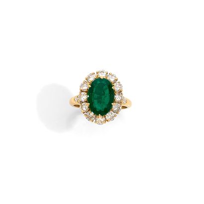 BAGUE Important 18K gold daisy ring, set with an oval emerald in a setting of twelve...