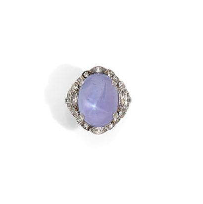 BAGUE A platinum, sapphire and diamonds ring, with an oval cabochon sapphire surrounded...