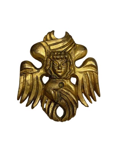 null Paule INGRAND (1910-1977). 
Broche en métal doré à décors de profils et ailes...