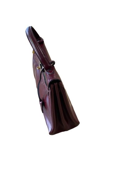 null Kelly" spirit bag in burgundy leather, gilded metal clasp fasteners, handle,...