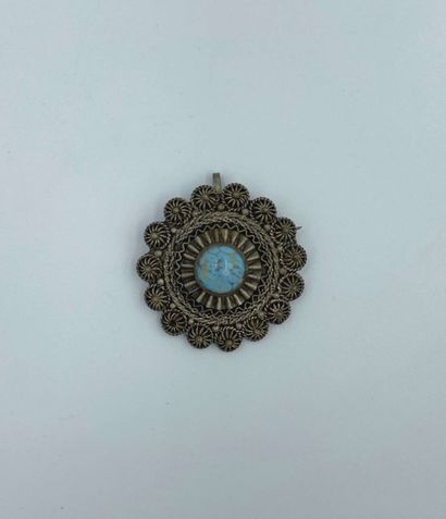 null Circular pendant in chased and openwork metal set with a turquoise. 

Diam,4...