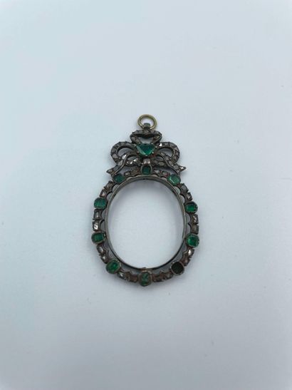 null Oval-shaped pendant with a silver (925) ribbon knot decorated with emeralds...