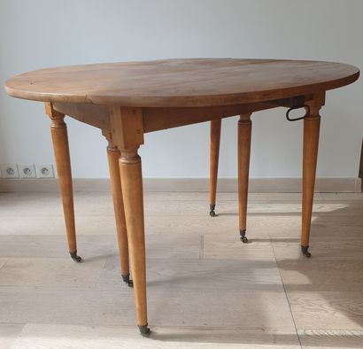 null Circular table with double flaps in natural wood, six tapered legs finished...