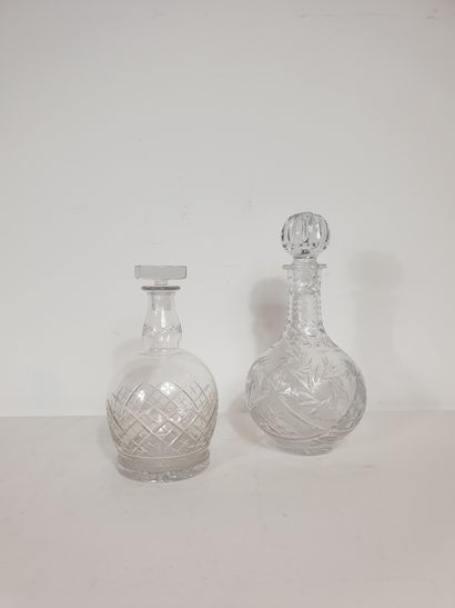 Two carafes in cut glassware with mismatched...