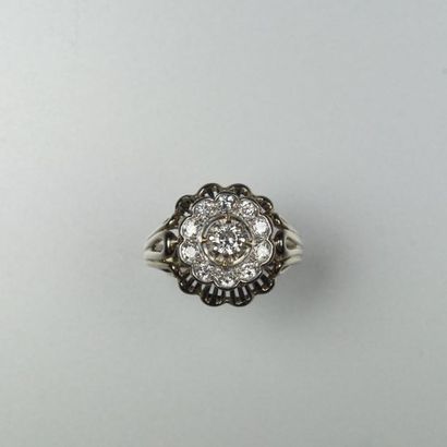null Bague « Fleur » en or gris 18K (750/oo) sertie d’un petit diamant dans un entourage...