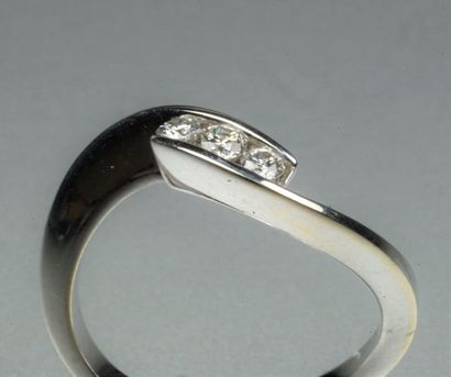 GAREL : Bague sinueuse en or gris 18K (750/oo) à décor croisé centrée de trois diamants...