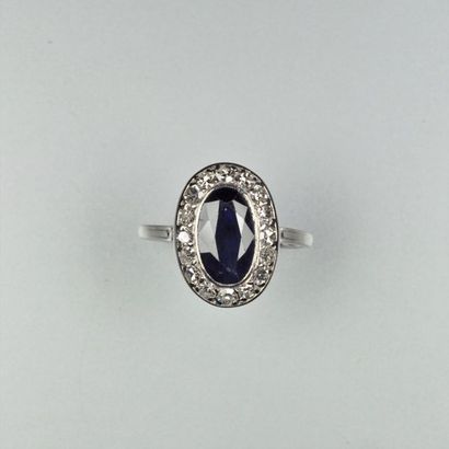 null Bague en platine (850/oo) centrée d'un saphir ovale dans un entourage de diamants...