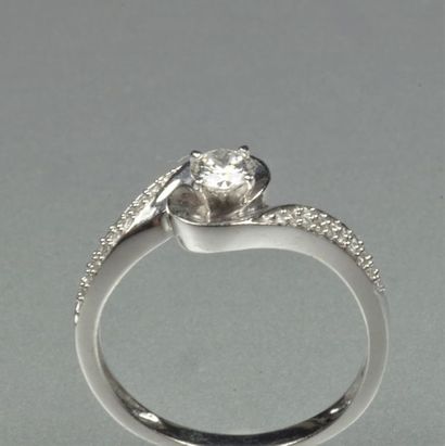 null Bague croisée en or gris 18K (750/oo) centrée d'un diamant taille brillant calibrant...