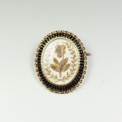 Oval brooch in 18K (750/oo) yellow gold centered...