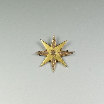 null Broche ancienne en or jaune 18K (750/oo) figurant une étoile à 8 branches agrémentée...