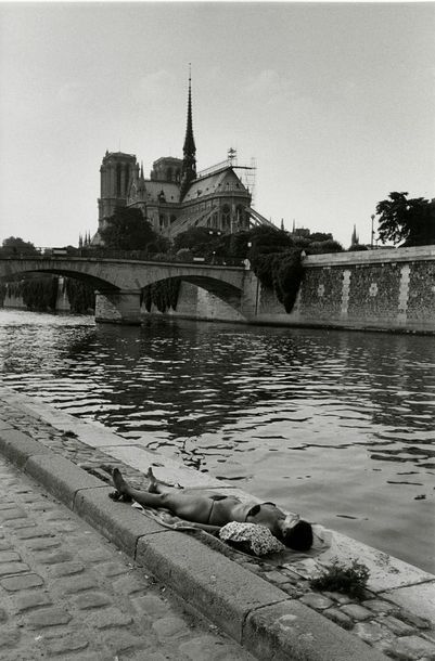 France Femme bronzant sur un quai près de Notre-Dame, Paris, 1981.. Tirage argentique...