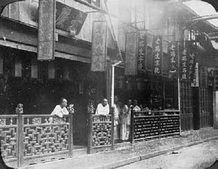 WILLIAM SAUNDERS actif 1863-1888 Maison de thé dans une rue de Shanghai, ca. 1876....