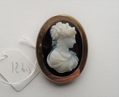 null Broche en or jaune 18K (750/oo) centrée d'un camée ovale sur onyx figurant un...