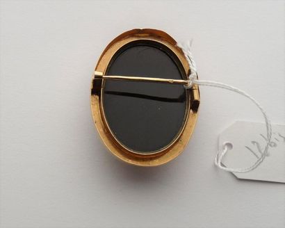  18K (750/oo) yellow gold brooch centered with an oval cameo on onyx depicting an...