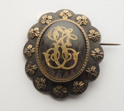  Broche ovale festonnée en argent (800/oo) centrée d'un motif sous verre de cheveux...