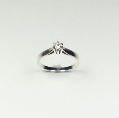 null Bague solitaire en or gris 18K (750/oo) centrée d'un diamant taille brillant...